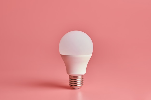 Light bulb on pink surface