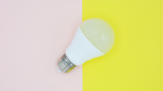 Light bulb on pink and yellow paper