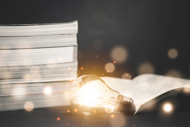 Light bulb and  vintage book with blurred lights