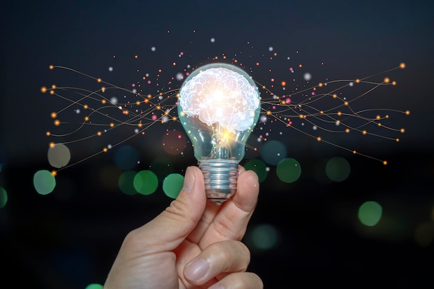 Light bulb with brain inside the hands of the businessman