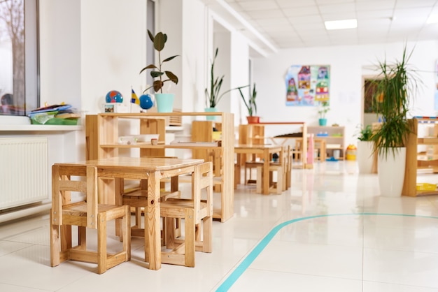 Light class kindergarten. wooden children's table with chairs in the foreground.