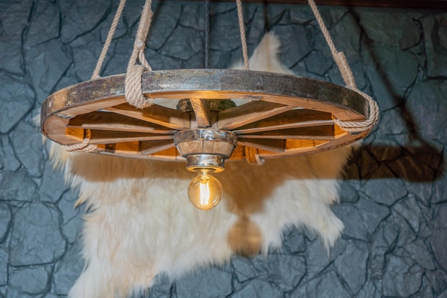 A light fixture hangs from a wall in a lodge.