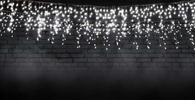 Light garland on a dark brick wall Reflection of lights on the asphalt Neon light smoke smog