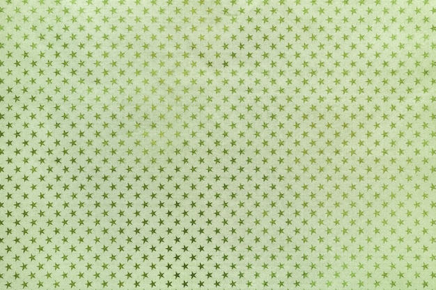 Light green background from metal foil paper with a stars pattern