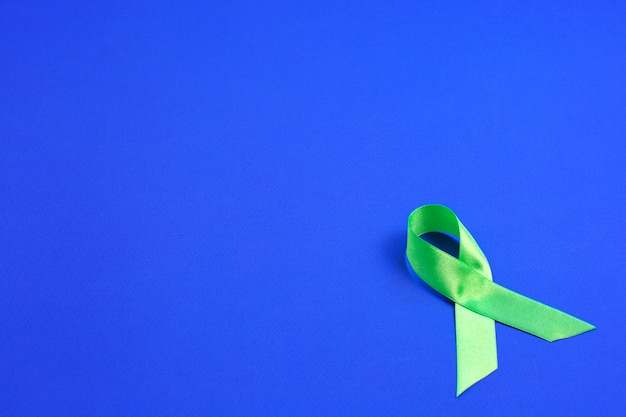 Light green ribbon on blue background. Liver Cancer Lymphoma Awareness. Healthcare and medicine concept.