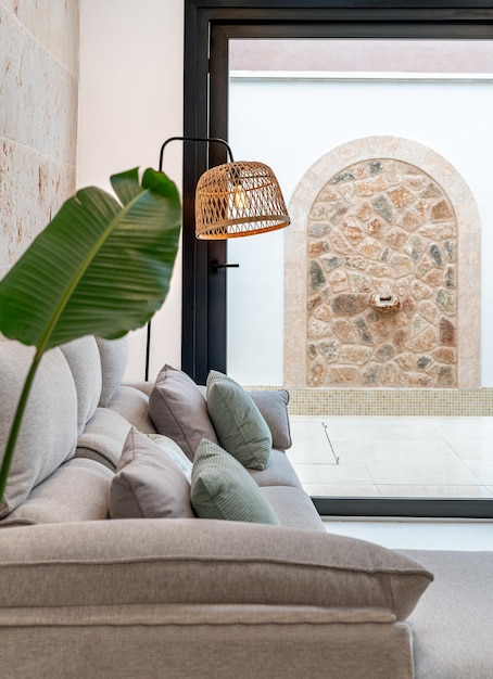 Light grey living room sofa with pillows next to a window