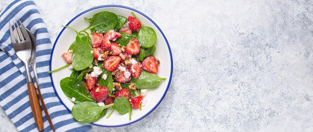 Light healthy summer salad with fresh strawberries spinach