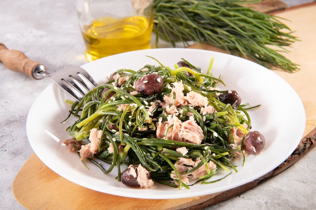 Light salad with agretti, a spring vegetable from Italy, tuna, black olives and olive oil