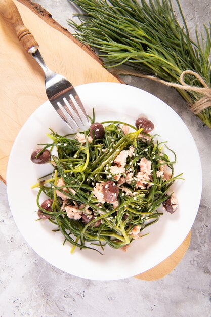 Light salad with agretti, a spring vegetable from Italy, tuna, black olives and olive oil