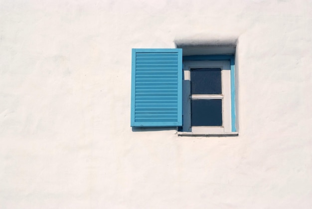 Light and shadow across on the blue window and the white wall