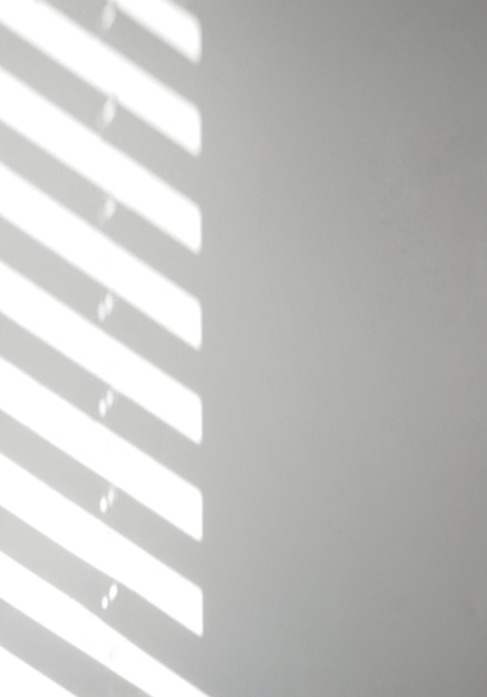 Light and shadows on a light wall through the window blinds Diagonal parallel lines abstract