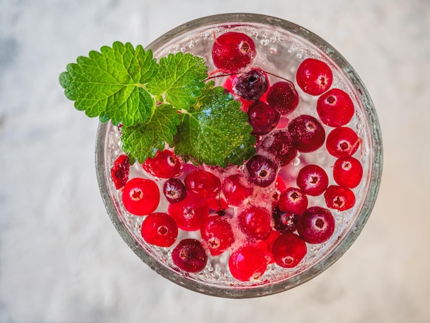 Photo a light soft drink with mint and lingonberry in a glass glass from a high point of view