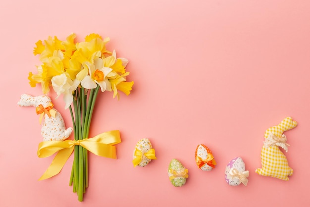 Light yellow spring bouquet and easter decor on pink background Spring flowers background with copy space