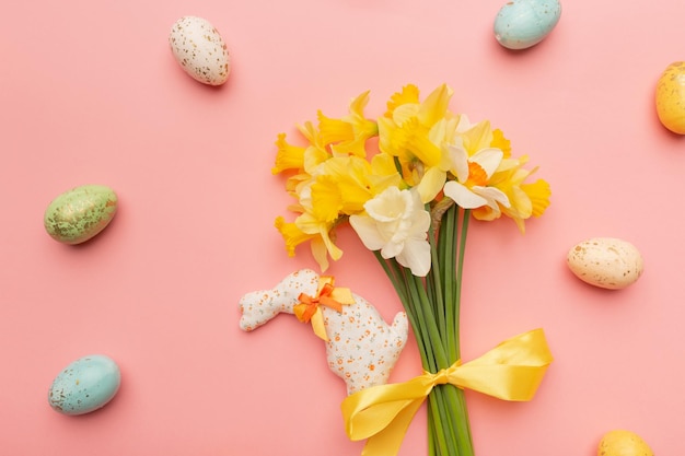 Light yellow spring bouquet and easter decor on pink background Spring flowers background