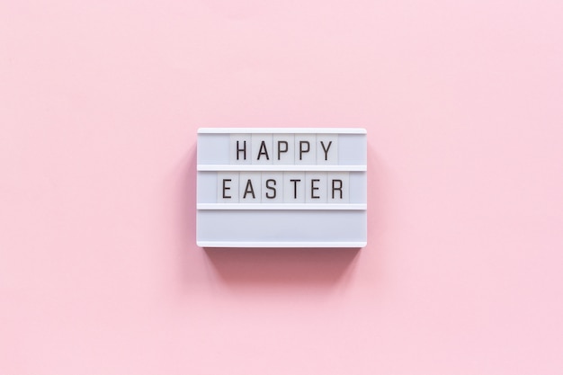 Lightbox text Happy Easter on pink paper background.