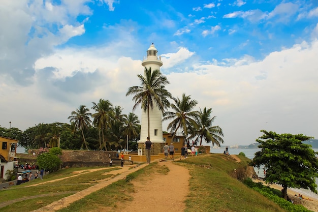 Photo lighthouse in galle fort sri lanka indian ocean shore palms blue cloudy sky sri lanka