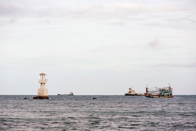 Lighthouse and ship in the sea.