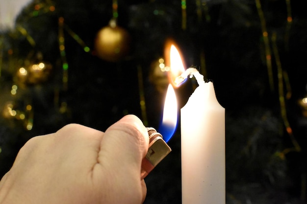 Lighting a candle with a lighter. burning candle in the dark