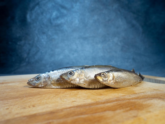 Lightly salted sprat on a cutting board Whole small fish on the table