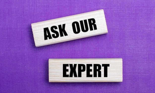 On a lilac bright background, light wooden blocks with the text ASK OUR EXPERT