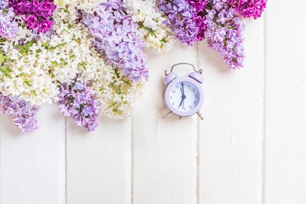 Lilac flowers branch on white wooden background with copyspace. Spring or mother day concept