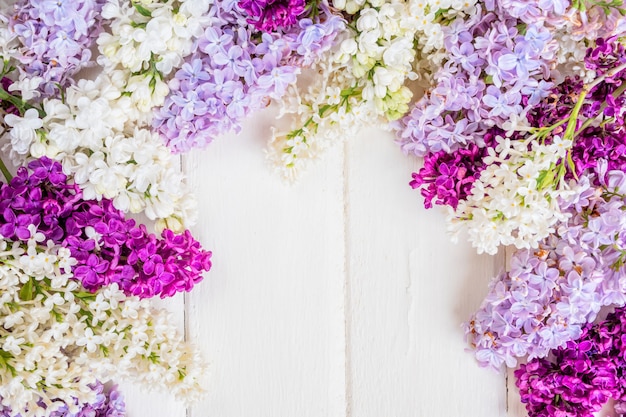 Lilac flowers branch on white wooden background with copyspace. Spring or mother day concept