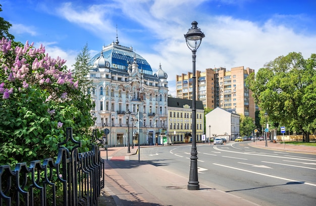 Lilac flowers and D. Elkind's apartment building on Bolshaya Nikitskaya street in Moscow on a summer sunny day