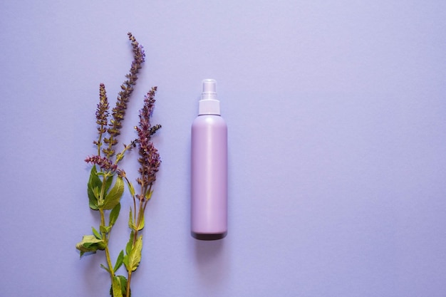 Lilac plastic bottle, dispenser, with lavender flowers on a light background. Copy space. Top view, flat lay