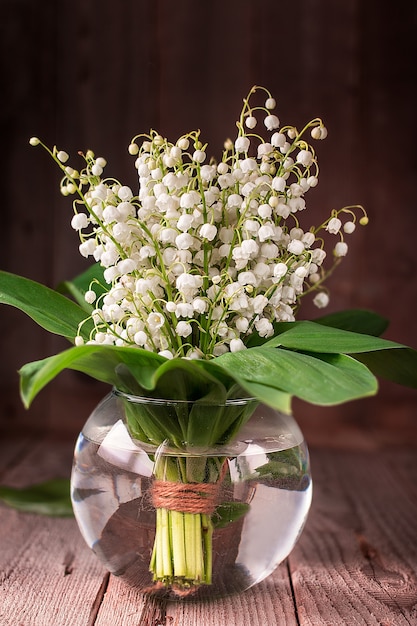 Lilly of valley in glass vase on wooden table