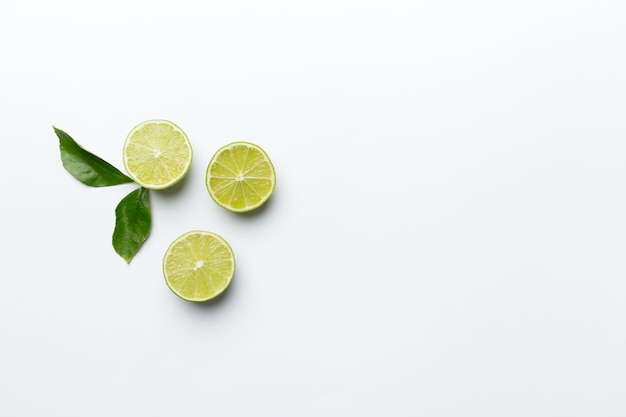 Lime fruits with green leaf and cut in half slice isolated on white background Top view Flat lay with copy space