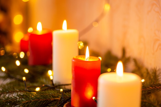 Line of burning red and white candles on fir tree branches