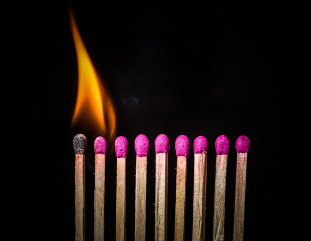 Photo line of lighted matches on black background