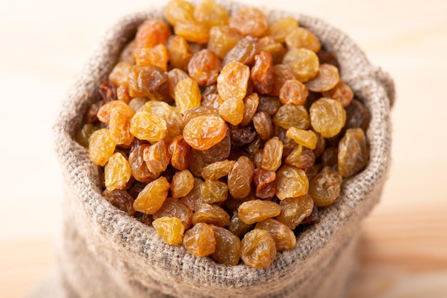 Linen bag of raisins on wooden table