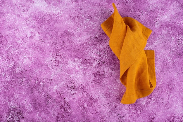 Linen napkin on lilac concrete background