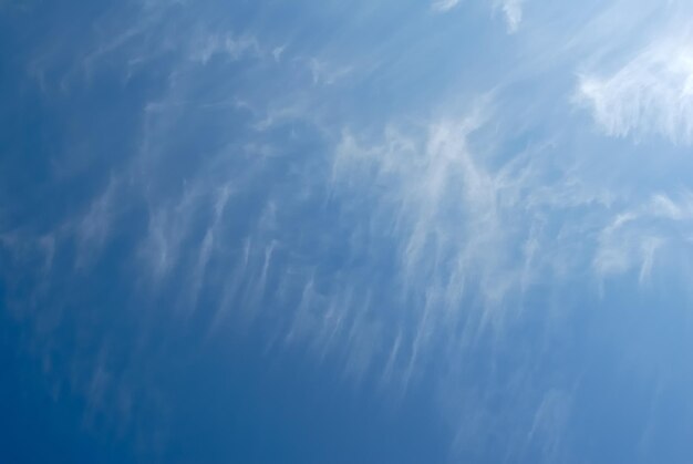 Lingering white clouds in the dark blue sky