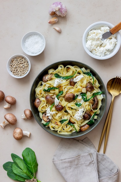 Linguine pasta with mushrooms, white cheese, spinach and garlic. Healthy eating. Vegetarian food. Diet.