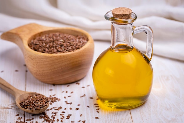 Linseed oil in a glass vessel and closeup flax seeds The concept of healthy eating