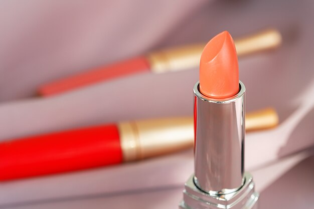 Lip gloss make up products on pink silky cloth