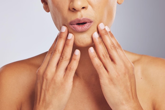 Lips pouting or hands of a woman for skincare beauty or dermatology wellness Closeup anti aging and mouth or manicure of a model for cosmetic nails or glow isolated on a studio background