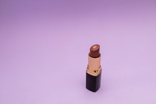 Lipstick in a bottle on a purple background