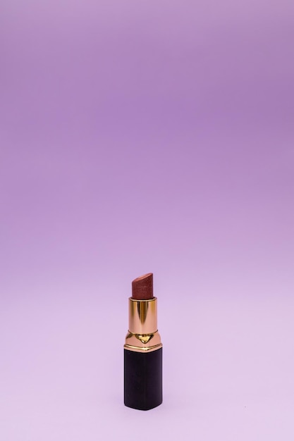 Lipstick in a bottle on a purple background