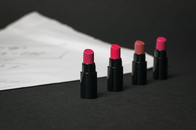 Lipstick samples on a white sheet on a black background