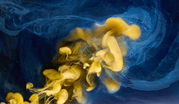 Liquid fluid art abstract background Blue yellow dancing acrylic paints underwater ocean space smoke