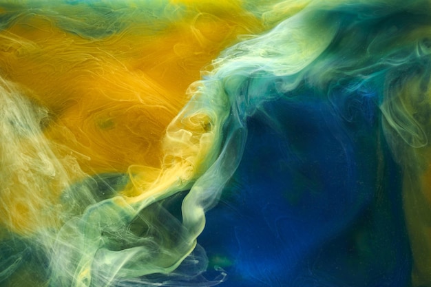 Liquid fluid art abstract background Blue yellow dancing acrylic paints underwater ocean space smoke