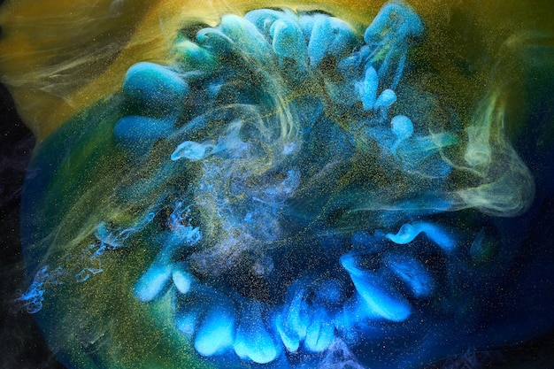 Liquid fluid art abstract background Blue yellow dancing acrylic paints underwater ocean space smoke