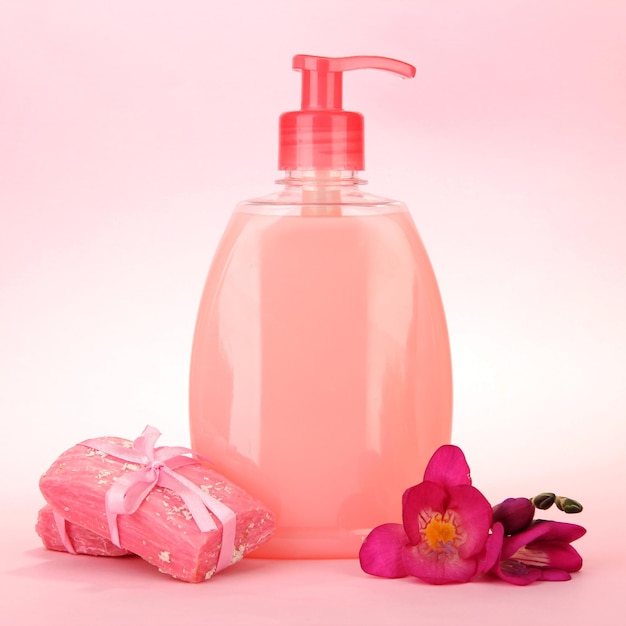 Liquid and handmade soaps on pink background