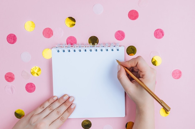 To do list in spiral notepad on pink festive background. Flat lay, top view.