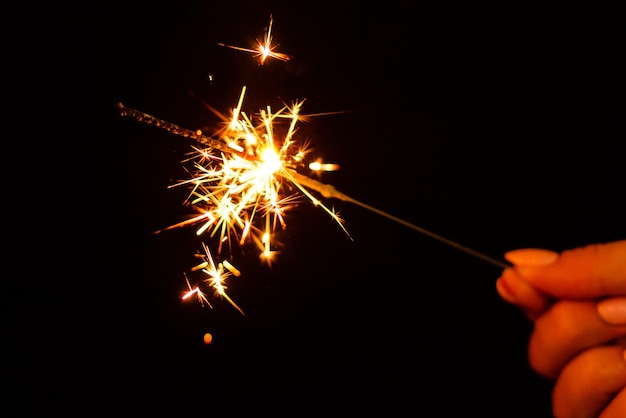 A lit sparkler showing bright sparks