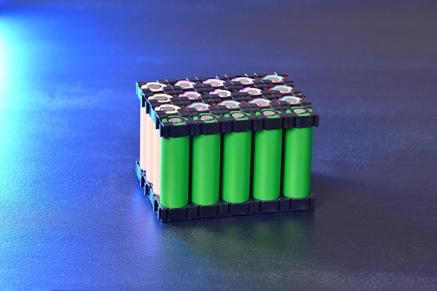 Lithium battery pack in black plastic holder in blue light.