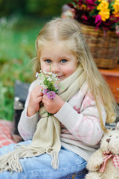 Litlle girl sitting on a blanket on the grass